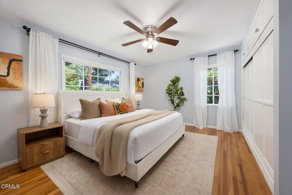 Primary bedroom with vaulted ceiling and hardwood floors
