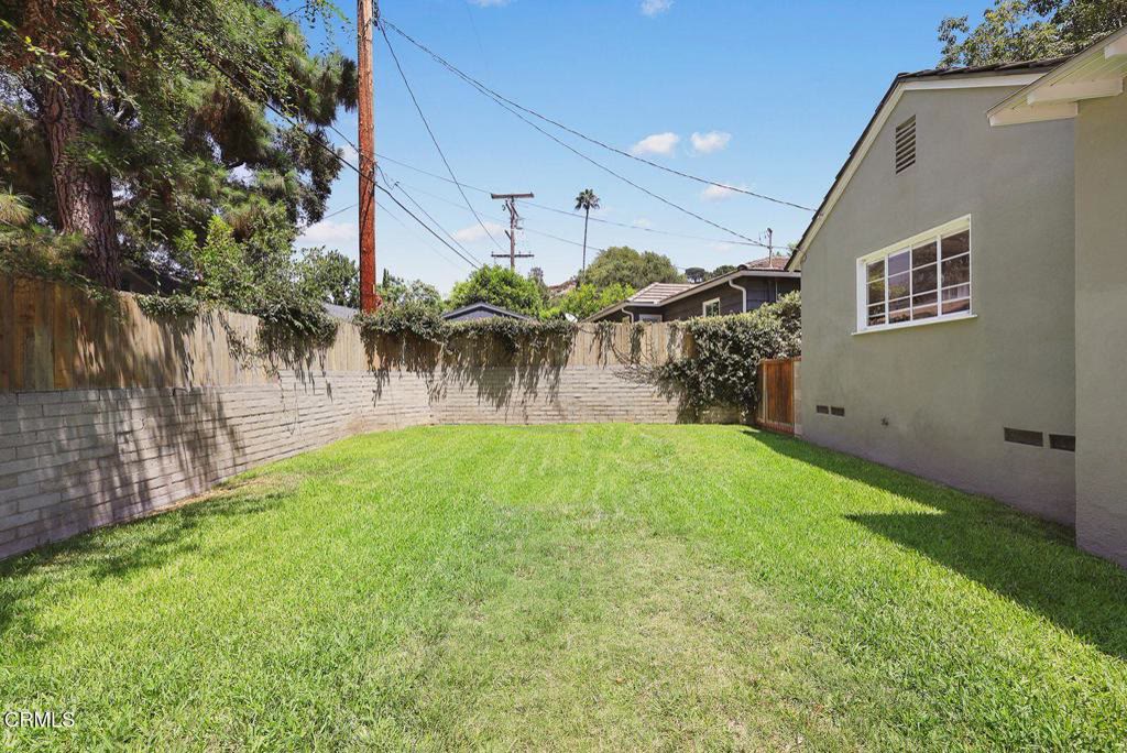 Generous grassy backyard bordered by mature trees
