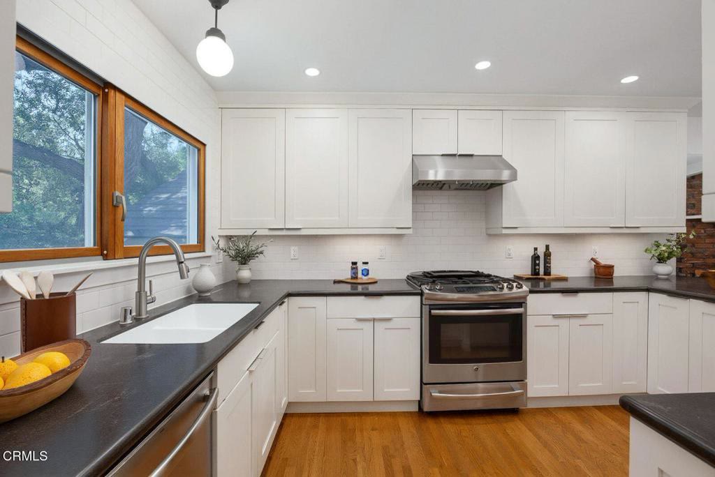 Remodeled kitchen with shaker cabinetry, solid counters and window over the sink