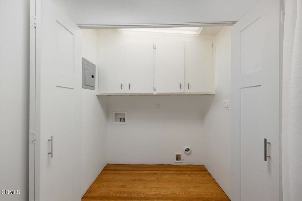 Indoor laundry closet with upper cabinetry