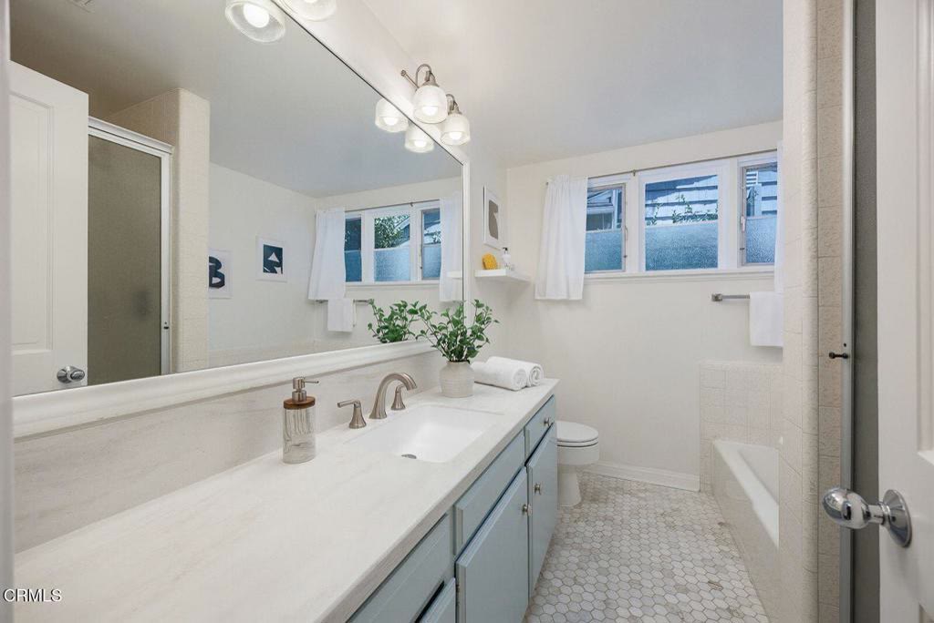 Full bath with long vanity and skylight